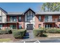Townhouse exterior with brick, dark gray roof, landscaping and wrought iron railing at 6851 Roswell Rd # H1, Sandy Springs, GA 30328