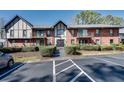 Townhouse exterior featuring brick, landscaping, and visible parking at 6851 Roswell Rd # H1, Sandy Springs, GA 30328