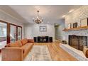 Inviting living room featuring a brick fireplace, hardwood floors, a stylish chandelier, and lots of natural light at 168 Woodland Valley Rd, Lawrenceville, GA 30046
