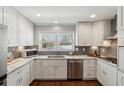 Well-lit kitchen with white cabinets, stainless steel appliances, granite countertops, and wood flooring at 3250 North Embry Cir, Chamblee, GA 30341