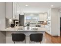 Open kitchen features granite countertops, stainless appliances, white cabinetry, and a breakfast bar at 3250 North Embry Cir, Chamblee, GA 30341