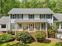 Inviting front elevation with a covered porch, brick accents, and manicured landscaping at 357 Breeze Hill Ln, Canton, GA 30114
