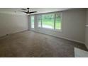 Spacious living room with a brick wall, ceiling fan, and a door leading to the backyard at 2463 Briarmoor Ne Rd, Atlanta, GA 30345