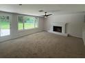 Bright living room featuring a fireplace, ceiling fan, and a large window overlooking the backyard at 2463 Briarmoor Ne Rd, Atlanta, GA 30345