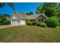 Inviting single-story home with a lush green lawn and mature trees adding to its charm at 648 Bellingham Dr, Sugar Hill, GA 30518