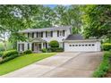 Beautiful two-story home with lush green lawn, mature trees, and a convenient two-car garage at 870 Richmond Hill Dr, Marietta, GA 30068