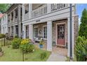 Inviting brick home with a charming porch, colorful flowers, and a 'Hello' doormat at 214 Bluestone Dr, Woodstock, GA 30188
