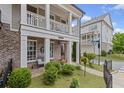 Charming brick home featuring a covered porch, well-maintained lawn, and beautifully landscaped front yard at 214 Bluestone Dr, Woodstock, GA 30188