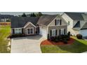 View of a house with a spacious driveway and well-kept lawn, showcasing suburban living at 3984 Potomac Walk Ct, Loganville, GA 30052