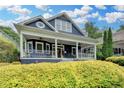 Charming two-story home with a covered front porch and manicured landscaping under a beautiful blue sky at 799 Monroe Ne Dr, Atlanta, GA 30308