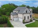 Aerial view of a brick home with an attached garage, landscaped yard and a concrete driveway at 1525 Tapestry Rdg, Lawrenceville, GA 30045
