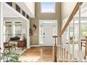 Bright foyer with hardwood floors, a wooden staircase, and a view into other rooms through large open archways at 10540 Waters Ridge Dr, Alpharetta, GA 30022