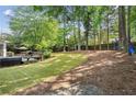 Spacious backyard featuring a lush lawn, mature trees, and a wooden deck for outdoor entertaining at 3322 Woodsfield Ne Dr, Marietta, GA 30062