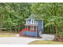 Charming two-story home with a covered porch nestled within a lush, green forest setting at 1310 Ridgeview Rd, Auburn, GA 30011