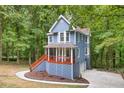Charming two-story home features a covered porch, upper deck, and is surrounded by a lush, wooded landscape at 1310 Ridgeview Rd, Auburn, GA 30011