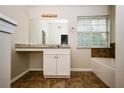 Bathroom features a vanity with a large mirror and a window providing natural light at 4438 Tuckahoe Ct, Douglasville, GA 30135