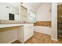 Bathroom features a tub with tiled walls and a vanity area with a large mirror at 4438 Tuckahoe Ct, Douglasville, GA 30135