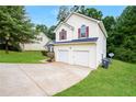 Two-story home featuring a two-car garage, well-maintained lawn, and traditional architectural details at 4438 Tuckahoe Ct, Douglasville, GA 30135