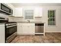 Galley-style kitchen showcasing stainless steel appliances, stone countertops and tile flooring at 4438 Tuckahoe Ct, Douglasville, GA 30135