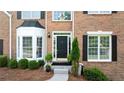 Inviting front entrance with a black door, decorative plants, and classic brickwork at 455 Firelite Ln, Suwanee, GA 30024