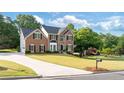 Charming brick home with a long driveway and manicured lawn, set in a lush, green neighborhood at 455 Firelite Ln, Suwanee, GA 30024