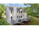 Expansive back of home featuring a large deck, neutral siding, and picturesque green surroundings at 455 Firelite Ln, Suwanee, GA 30024