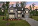 Charming brick home with manicured lawn, illuminated landscaping, and a welcoming entrance at 6555 Hawkins Manor Dr, Cumming, GA 30040