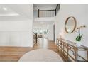 Bright foyer features wood floors, a staircase, and stylish console table with decorative mirror at 6555 Hawkins Manor Dr, Cumming, GA 30040