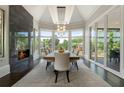 Bright dining room with fireplace, a chandelier, and large windows showcasing a lush outdoor view at 1145 Lake Shore Overlook, Alpharetta, GA 30005