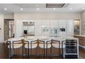 Modern kitchen features bar seating, sleek cabinetry, stainless steel appliances, and a wine refrigerator at 1145 Lake Shore Overlook, Alpharetta, GA 30005