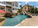 Luxury backyard pool with rock waterfall, water slide, in-ground spa, and lounge chairs on the patio at 1145 Lake Shore Overlook, Alpharetta, GA 30005