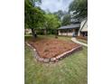 Spacious front yard with stone-bordered flower bed and well-maintained green lawn leading to the home at 218 Deerwood Se Ct, Smyrna, GA 30082