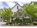 Elegant home exterior featuring manicured landscaping, lush trees, a pedestrian gate, and architectural details at 1100 Parker Ne Pl, Atlanta, GA 30324