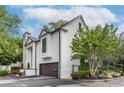 A stucco home boasting a convenient front-entry garage, complemented by beautiful landscaping, and pedestrian gate at 1100 Parker Ne Pl, Atlanta, GA 30324