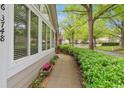 Exterior shot of home with well-manicured bushes along a sidewalk lined street and neighborhood in the background at 3746 Vineyards Lake Nw Cir # U6, Kennesaw, GA 30144