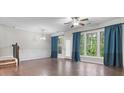 Spacious living room featuring hardwood floors, large windows, and elegant trim work at 7168 Kingswood Run Dr, Atlanta, GA 30340