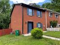 View of the brick facade townhome featuring blue shutters and a well-maintained lawn at 1001 Park Gate Pl, Stone Mountain, GA 30083