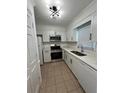 Well-lit kitchen boasts stainless steel appliances, white cabinets and quartz countertops at 1001 Park Gate Pl, Stone Mountain, GA 30083