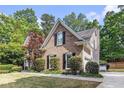 Charming brick home featuring black shutters and manicured lawn at 1235 Legend Run, Alpharetta, GA 30005