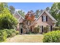 Charming brick home featuring mature landscaping, a well-maintained lawn, and classic black shutters at 1235 Legend Run, Alpharetta, GA 30005