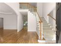 Bright foyer with hardwood floors, staircase with white railings, and arched doorway leading to other rooms at 679 Gold Valley Pass, Canton, GA 30114
