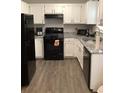 Well-lit kitchen with granite countertops, black appliances, and ample cabinet space at 985 Romer Pl, Stone Mountain, GA 30083