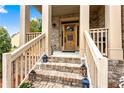 Inviting front porch with brick stairs and decorative lanterns leading to a wood front door at 1114 Ivey Chase Pl, Dacula, GA 30019