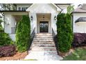 Elegant stone stairway leading to a front door flanked by manicured shrubs and lantern lighting at 23 Long Island Pl, Sandy Springs, GA 30328