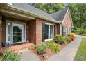 Close-up of brick home's front entrance, highlighting landscaping and covered porch at 2297 Ironwood Hill Ct, Dacula, GA 30019
