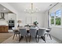 Elegant dining room featuring modern chandelier, neutral walls, hardwood floors, and large windows at 572 Cresentry Brk, Smyrna, GA 30082