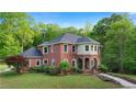 Charming red brick two-story home with lush landscaping, a manicured lawn, and an inviting entrance at 8032 Banks Mill Rd, Douglasville, GA 30135