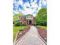 Stunning two-story brick home showcasing a beautiful walkway and professionally landscaped front yard at 8032 Banks Mill Rd, Douglasville, GA 30135