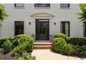 Elegant front entrance featuring black door, brick steps, and decorative plantings at 2180 Dunwoody Heritage Dr, Atlanta, GA 30350