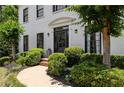 Close up of front entrance with lush greenery and curved walkway, framed by verdant landscaping at 2180 Dunwoody Heritage Dr, Atlanta, GA 30350